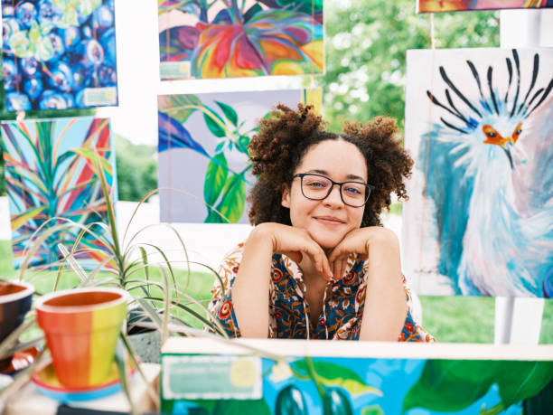 smiling woman selling artworks at an outdoor market